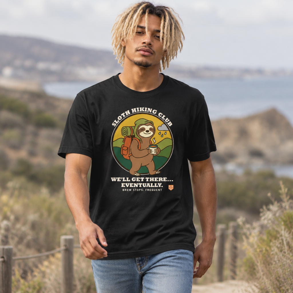 Man walking a coastal trail wearing the Sloth Hiking Club: Walking T-Shirt in Vintage Black