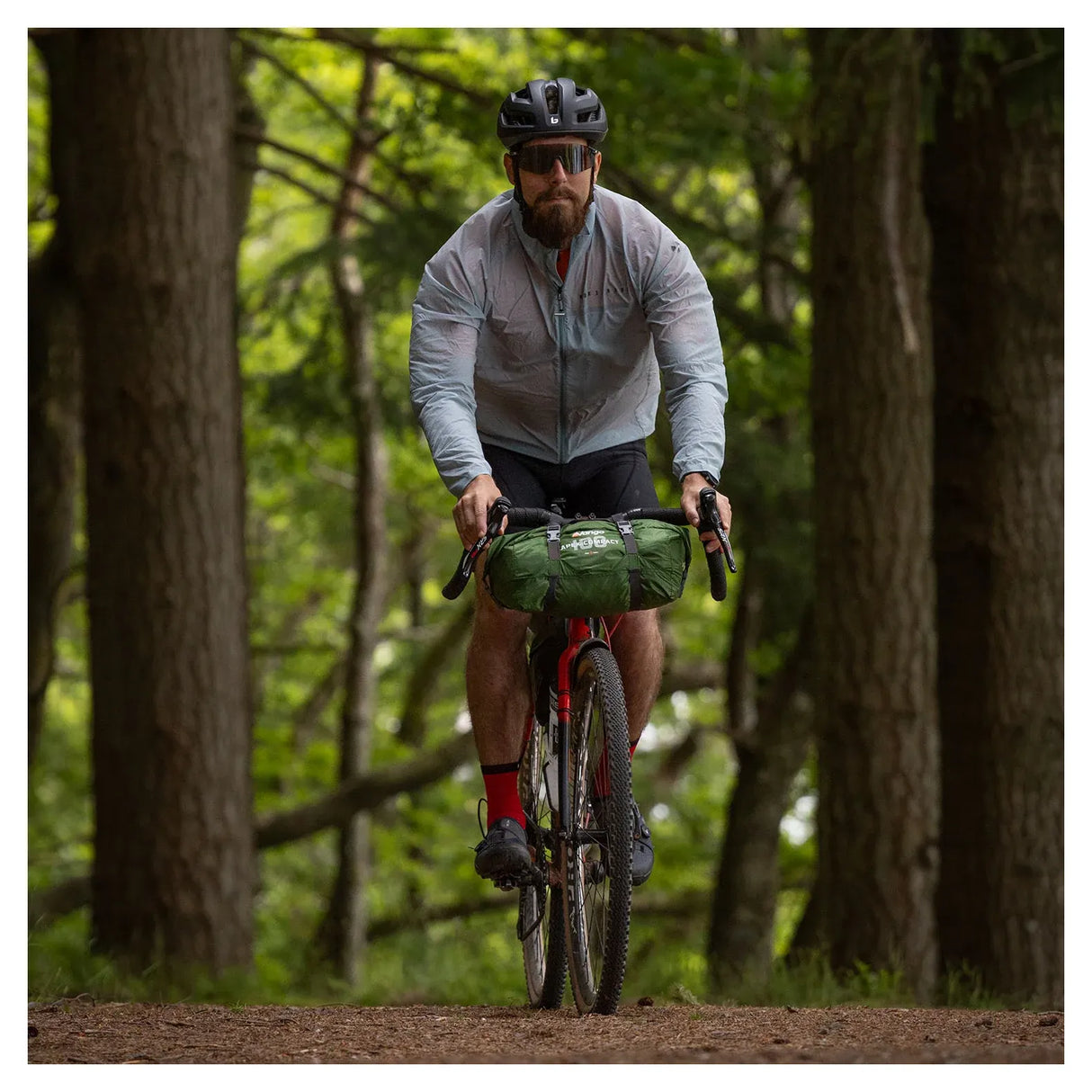 Cyclist on a forest trail carrying the Vango Apex Compact 100 tent