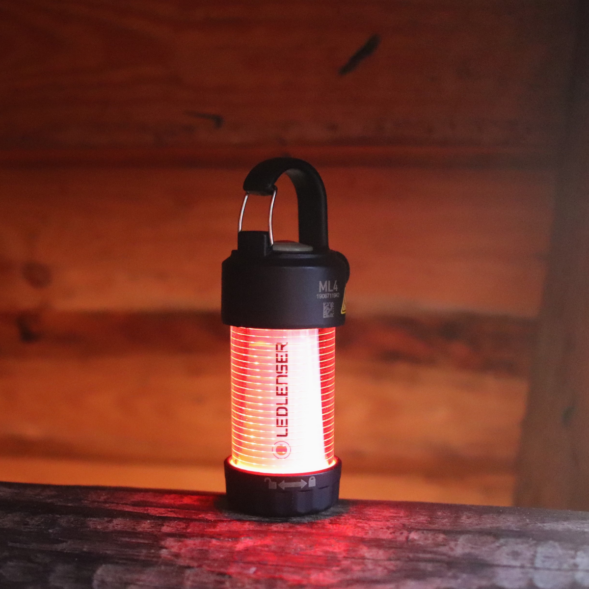 Ledlenser ML4 mini lantern glowing red on a wooden log