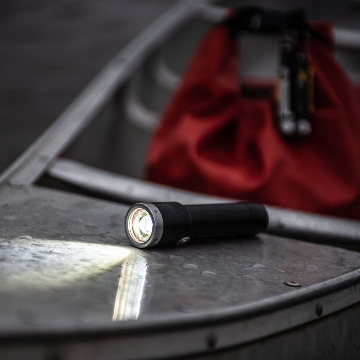 Ledlenser MT torch lighting the wet deck of a canoe