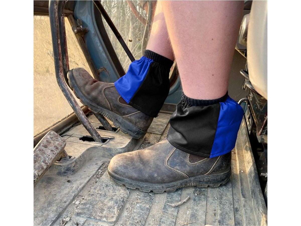Black and royal blue harlequin sox savers worn over work boots in a cab
