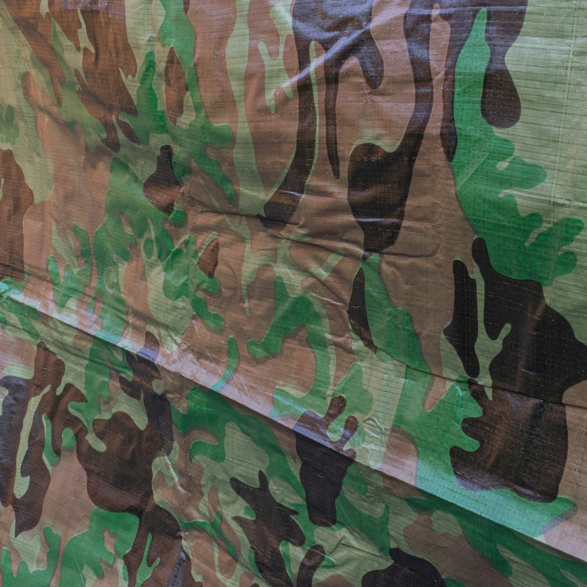 Folded edges of the Camouflage M-Grade Tarpaulin 1m x 1m with an eyelet