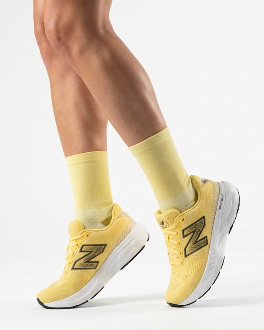 Runner's lower legs in Stride Yellow Haze half crew running socks with pale yellow running shoes