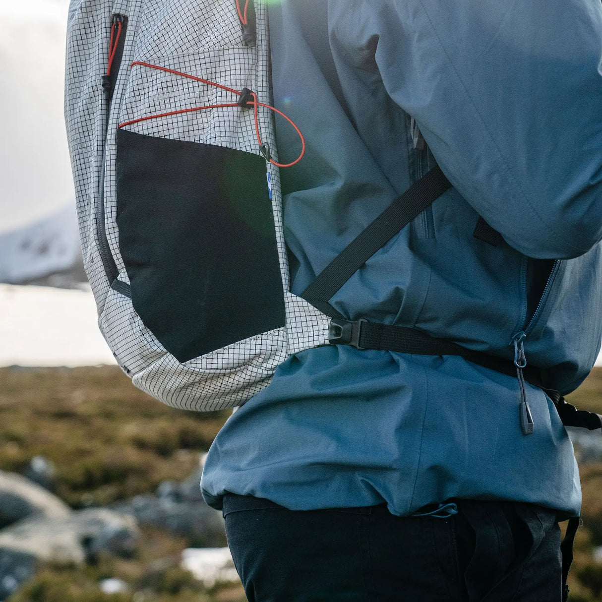 Highlander Kynetik Rucksack 15L in White - close-up of the side pocket and waist strap worn on the hill