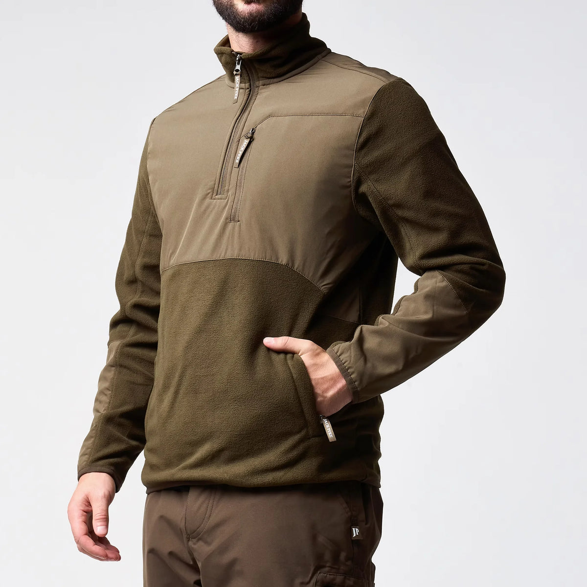 Jack Pyke Rannock Fleece Pullover in dark olive worn by a model, side angle with a hand in a zipped lower pocket