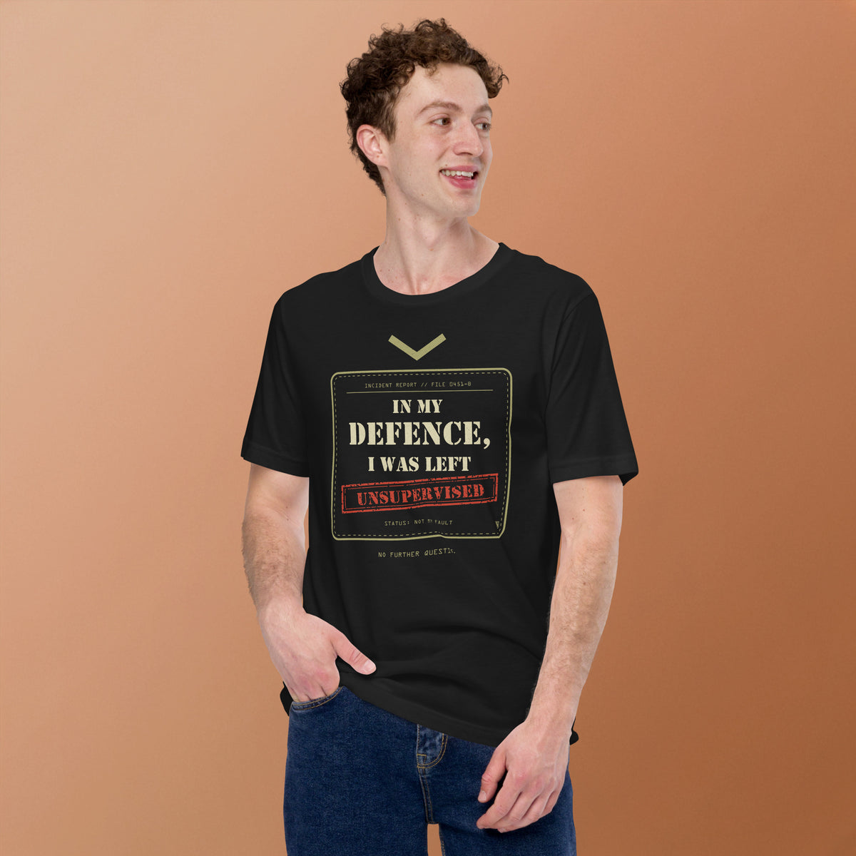 Man wearing the In My Defence, I Was Left Unsupervised T-Shirt in Vintage Black against an orange background