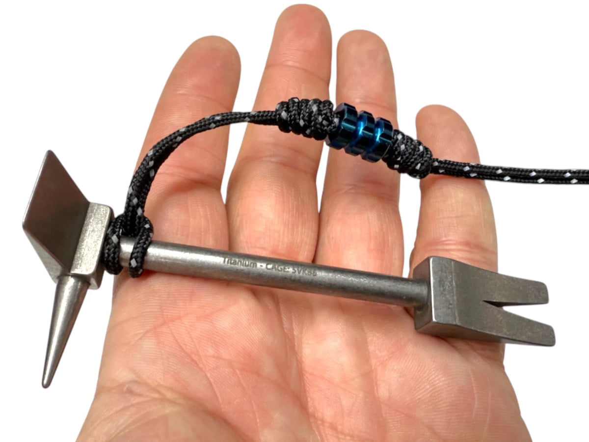 4 in Titanium Hooligan Bar and paracord lanyard across an open palm to show its size