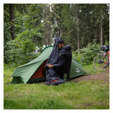Camper sitting in the porch of the Vango Apex Compact 100 tent in woodland
