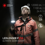 Worker in a hard hat and hi-vis jacket shining the Ledlenser P21R upwards