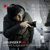 Man in a beanie searching with the Ledlenser P18R