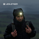 Walker in a waterproof hood in the rain wearing the Ledlenser MH10 SE