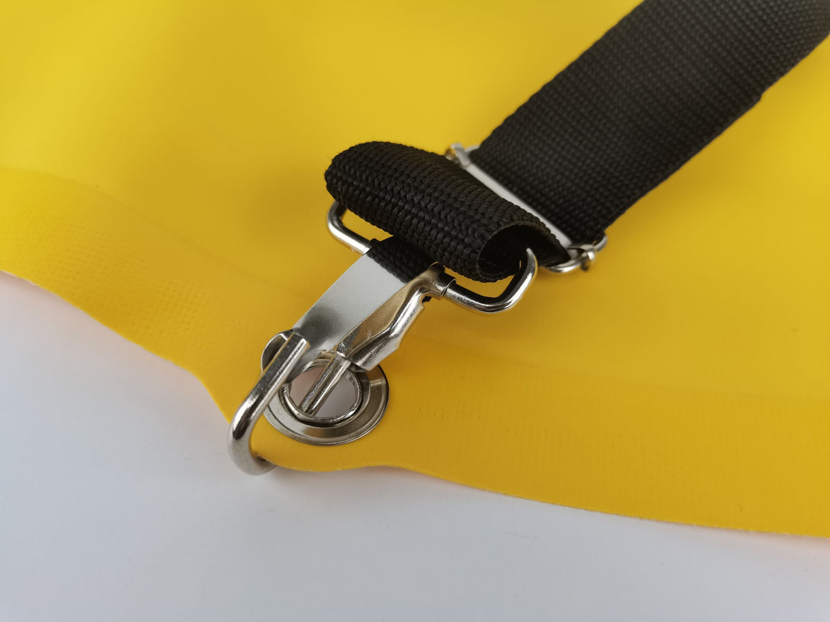 Close-up of a harness strap snap hook and buckle on the yellow PVC pack