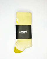 Stride Yellow Haze running sock folded in its black STRIDE card sleeve