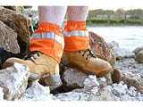 Fluro orange sox savers with 3M reflective strip worn over tan safety boots on rubble