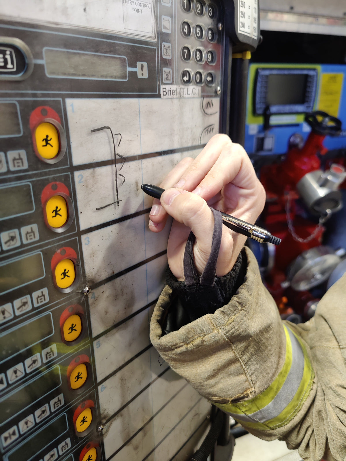 Firefighter writing on a BA entry control board with a black Listo 1620 chinagraph pencil