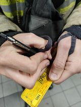 Black Listo 1620 chinagraph pencil marking a yellow BA tally, held in a firefighter's hands