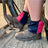 Navy and fuchsia harlequin sox savers worn over work boots in a tractor footwell