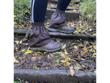 Brown oilskin hikers gaiters worn over walking boots on muddy woodland steps