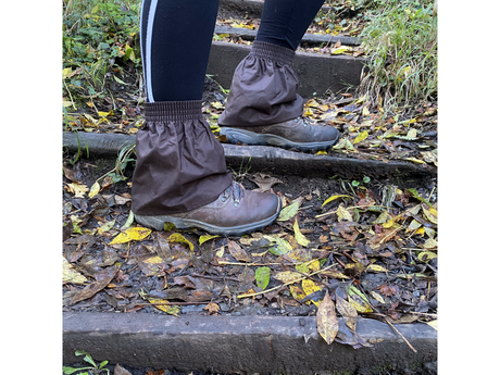 Brown oilskin hikers gaiters worn over walking boots on muddy woodland steps