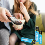 Person holding a TV remote beside Maplin alkaline batteries