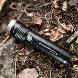 Ledlenser MT14 torch with hand strap lying on the forest floor