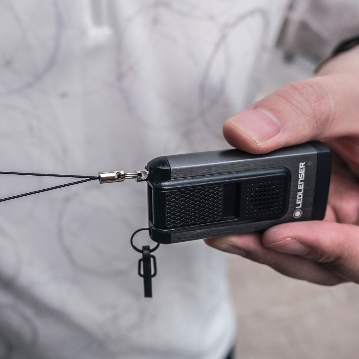 Hand holding the Ledlenser K6R Safety with its alarm pin pulled out