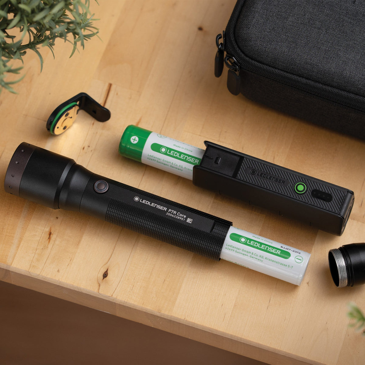 Ledlenser 21700 battery sliding into the FLEX5 power bank beside a Ledlenser P7R Core torch with its battery out
