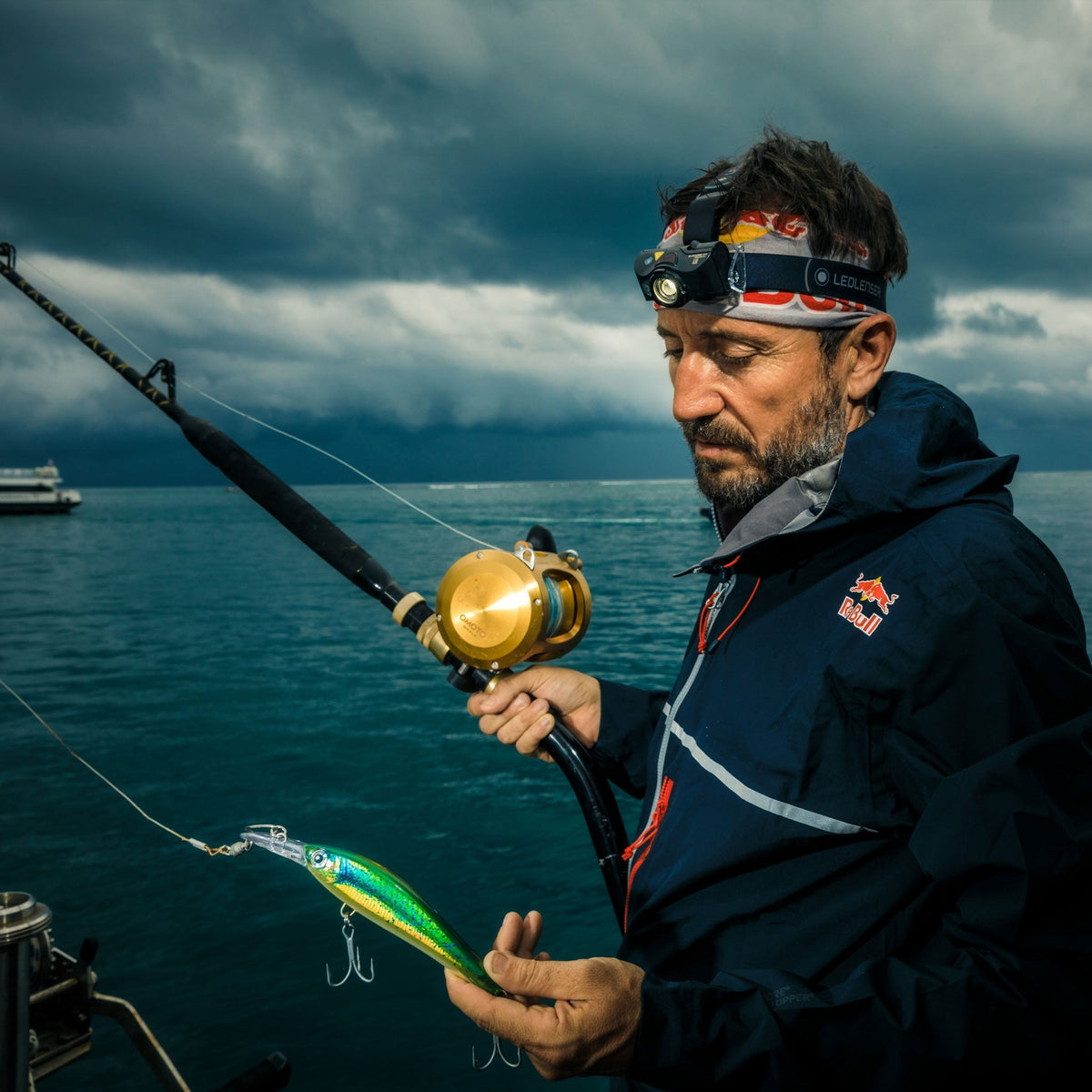 Angler holding a sea fishing rod and lure while wearing the Ledlenser MH8