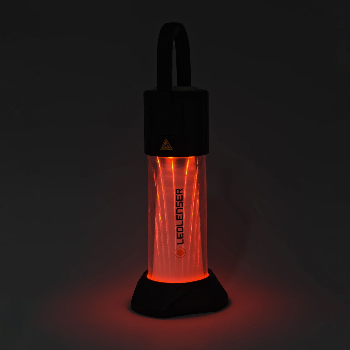 Ledlenser ML6 lantern glowing red on its stand in the dark
