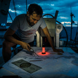 Sailor plotting a chart at night by the red light of the Ledlenser ML6