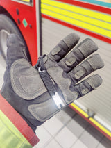 Black Mini Pry Bar lying across a firefighter's gloved palm