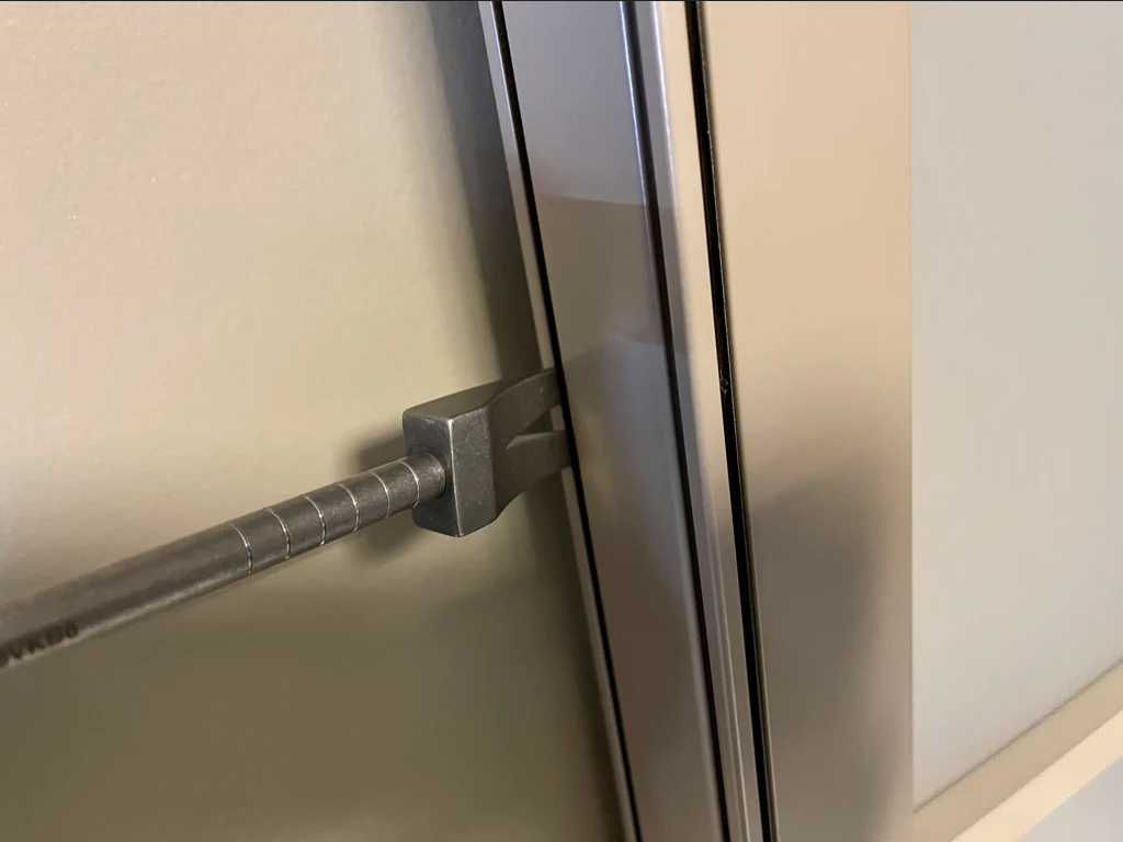 Wedge claw of the 8 in Titanium Hooligan Bar set in a door frame gap
