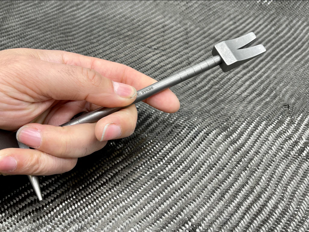 Hand holding the 8 in Titanium Hooligan Bar by the shaft, wedge claw up