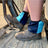 Navy and sky blue harlequin sox savers worn over boots in a tractor footwell