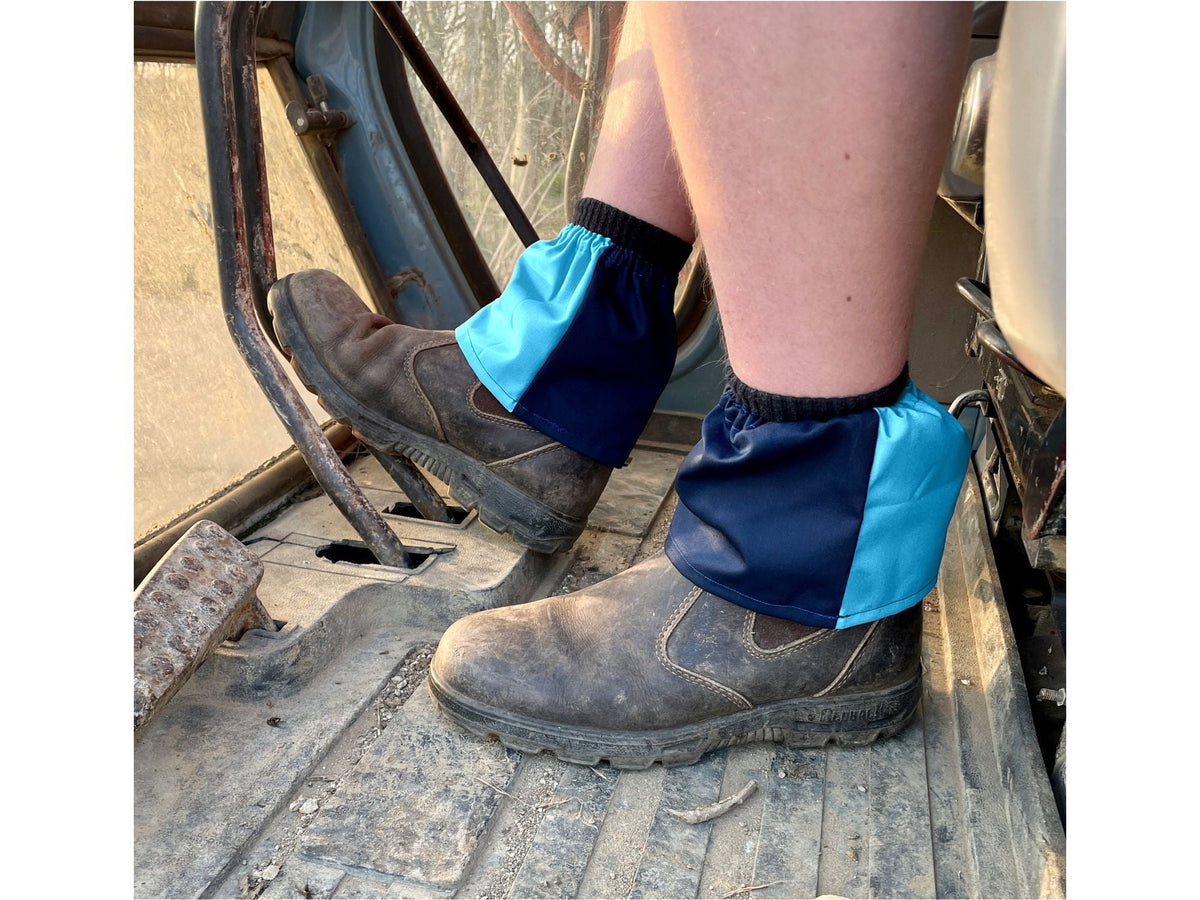 Navy and sky blue harlequin sox savers worn over boots in a tractor footwell
