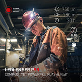 Industrial worker in a hard hat and safety glasses lit by the Ledlenser P5R