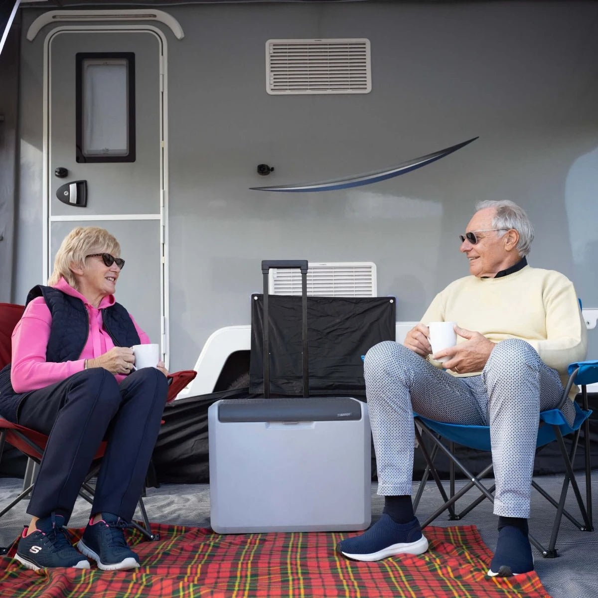 Couple with mugs of tea inside the Vango Palma Air 330 caravan awning
