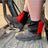 Black and red harlequin sox savers worn over dealer boots on a tractor step