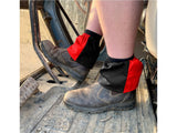 Black and red harlequin sox savers worn over dealer boots on a tractor step