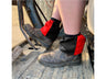 Black and red harlequin sox savers worn over dealer boots on a tractor step