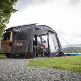 Campers sitting inside the Vango Sunlight awning beside their campervan
