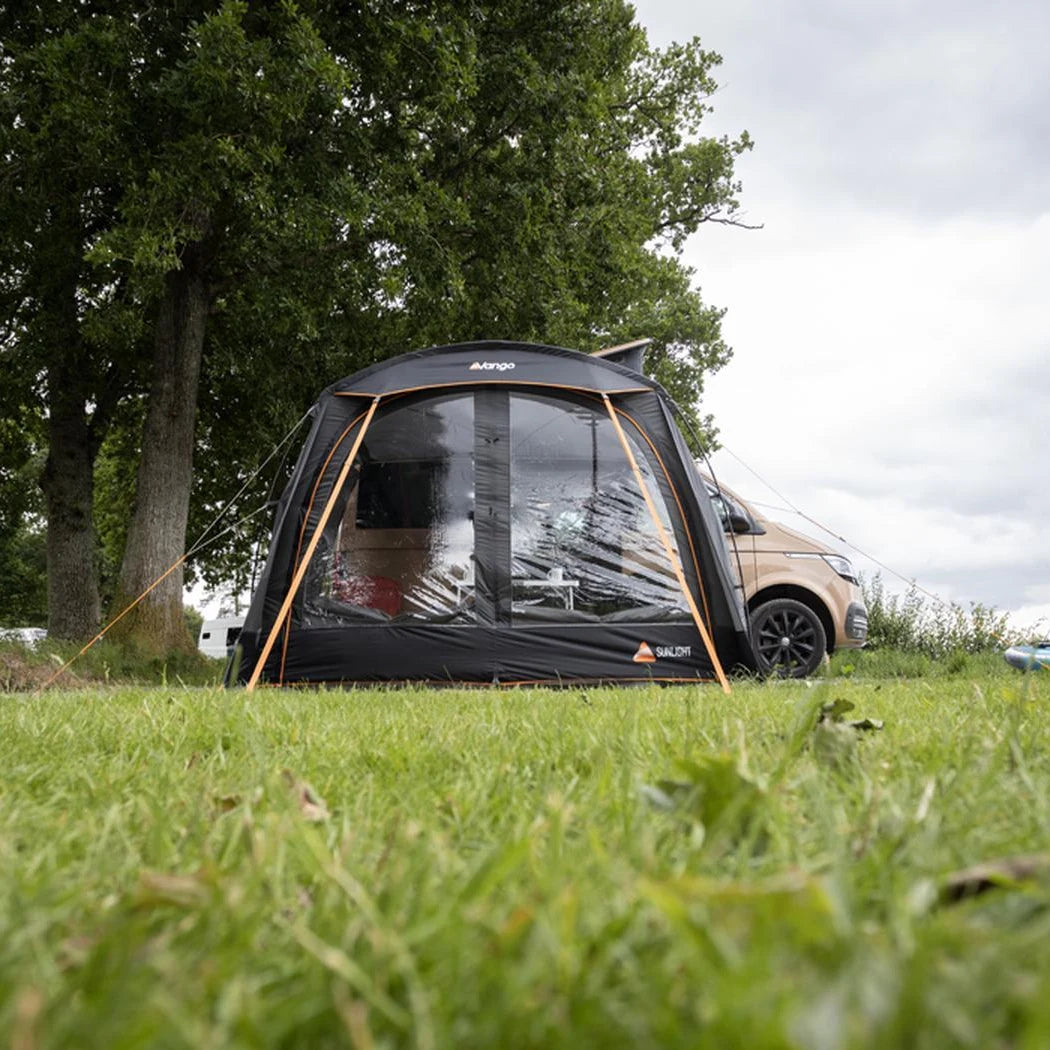 End view of the Vango Sunlight awning pitched on grass beside a campervan