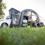 Two campers relaxing under the Vango Sunlight Air beside a campervan