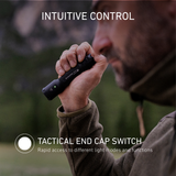 Close-up of a hand holding the Ledlenser TAC6R with thumb on the tactical end cap switch