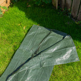 Green S-Grade Tarpaulin 1m x 1m laid out on a lawn beside a fence