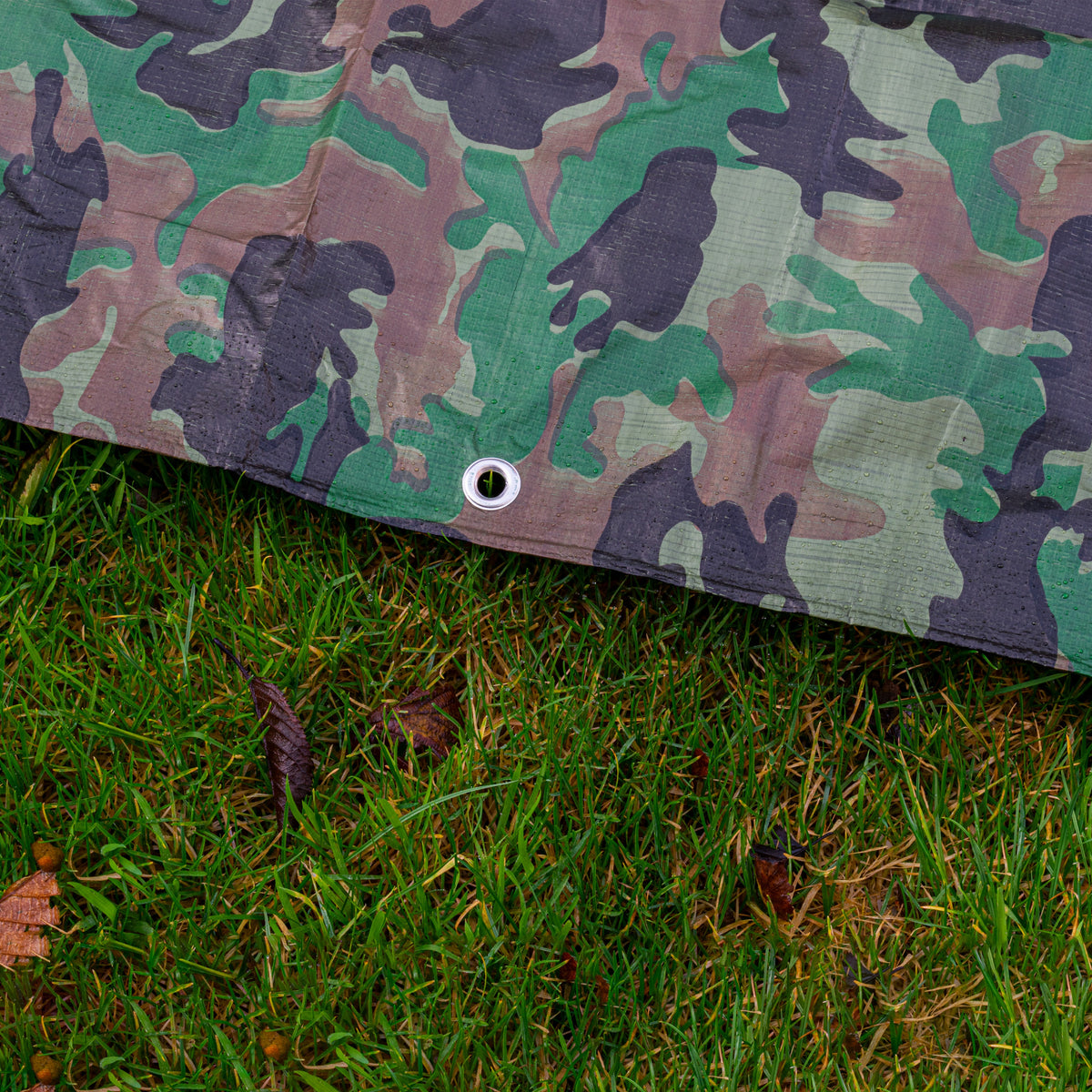 Camouflage M-Grade Tarpaulin 1m x 1m folded with one corner turned back to show the eyelets
