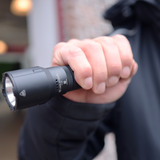 Close-up of a hand gripping the Ledlenser TT3R tactical torch