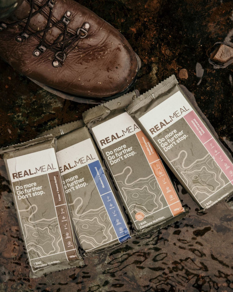 Real Meal Food Bar on the ground outdoors next to a boot