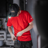 Tradesperson in a red T-shirt with the Ledlenser W1R Work clipped to a cap peak