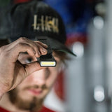 Electrician using a test meter with the Ledlenser W1R Work clipped to his jacket